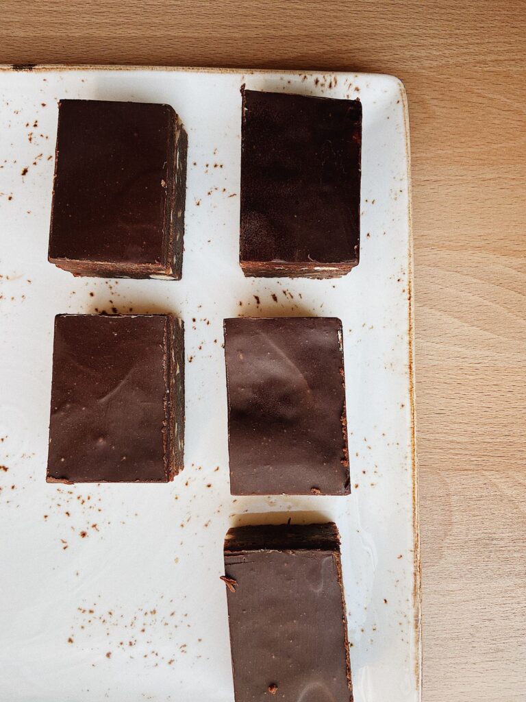 Squares of rich chocolate fudge arranged in rows on parchment paper